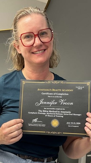 Jennifer holding a certificate in buccal massage treatment